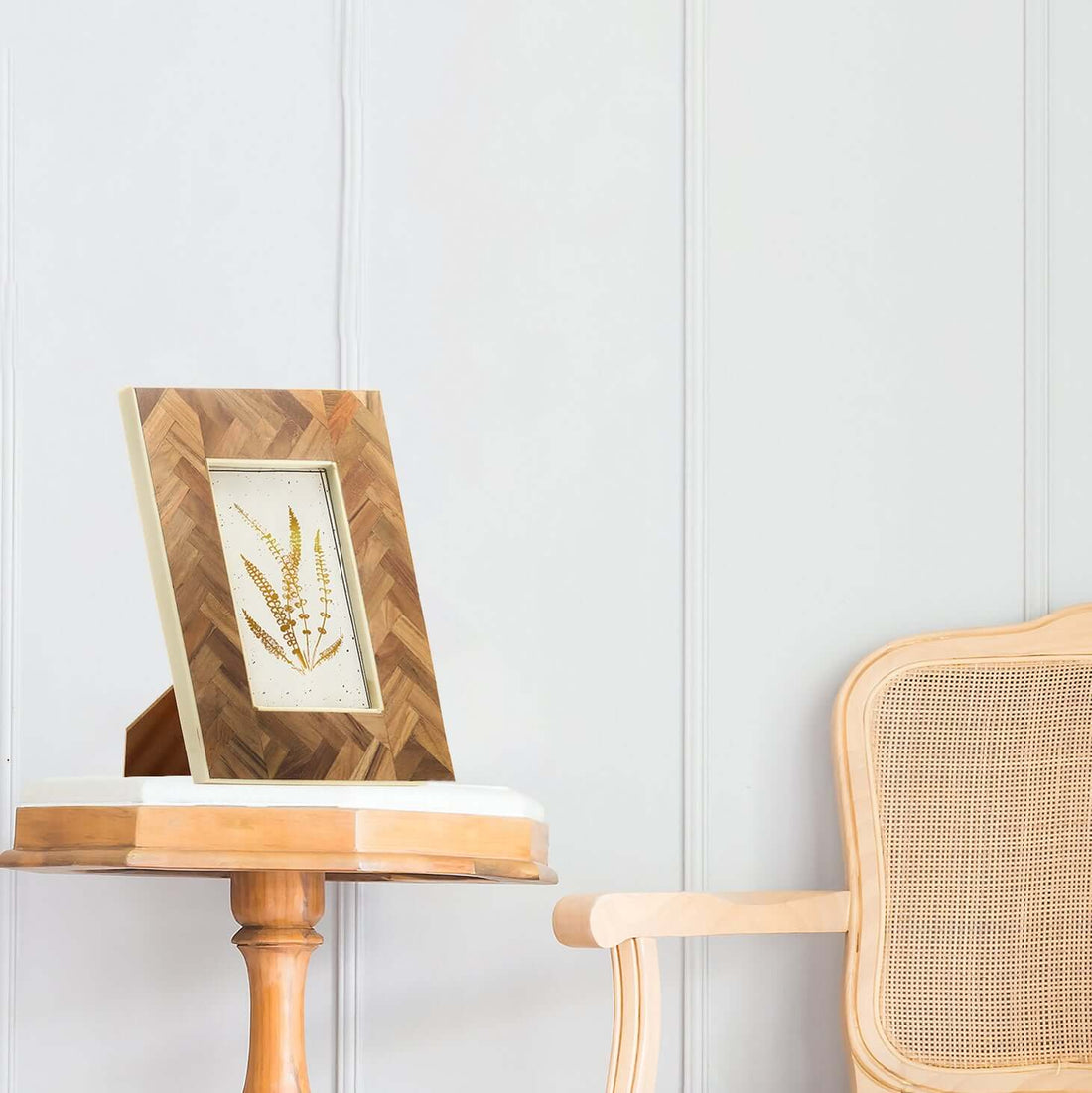 A resin and teakwood frame placed on a wooden side table in a home setting, displaying an artwork or photo.