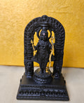A black statue of a deity, likely Lord Rama, holding a golden bow and arrow is shown on a decorative base. The statue is set against a yellow, textured background and is framed by an intricate black archway.