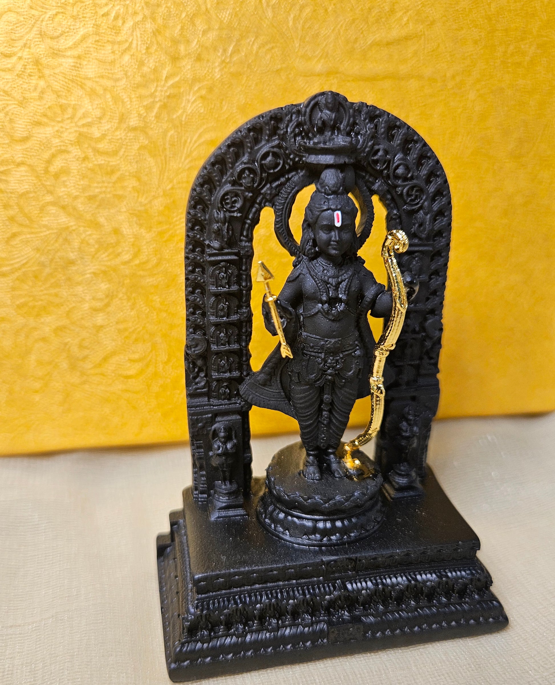 Intricately carved black polyresin idol of Lord Ram Lalla in a standing pose, holding a golden bow and arrow, adorned on a base