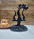 A black resin statue of Lord Shiva's Trishul (trident) with an attached Damru (drum) and an Om symbol, sitting on a base, likely a home decor showpiece