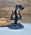 Matte black resin Trishul, Lord Shiva's trident, featuring a Damru and Om symbol, set on a dark, textured base