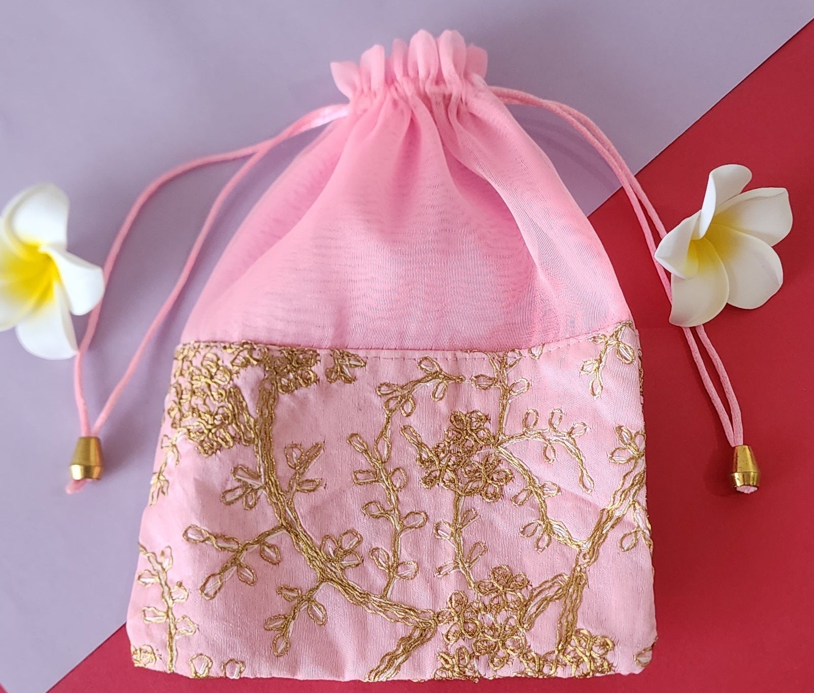 Pink Designer Potli pauch with Glden design on it.