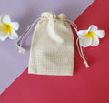 A beige Potli gift bag with a drawstring closure with rassi