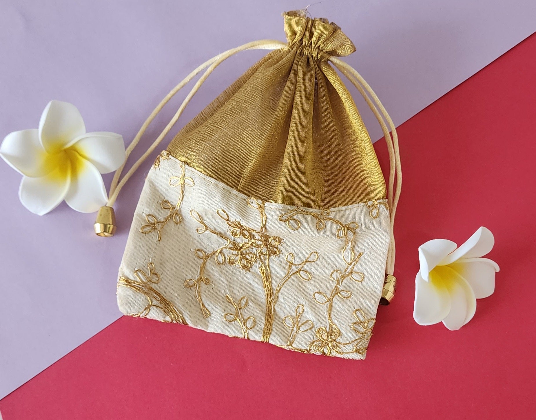 half beige Designer Potli pauch with flowers around it