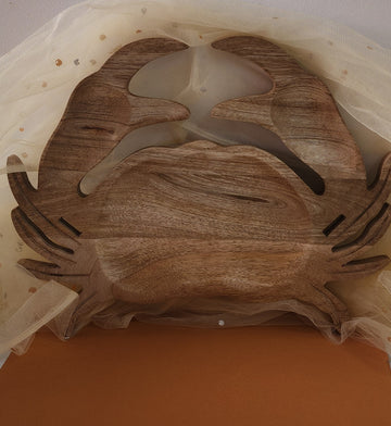 A wooden serving platter designed in the shape of a crab, with a rustic finish and natural wood colors.