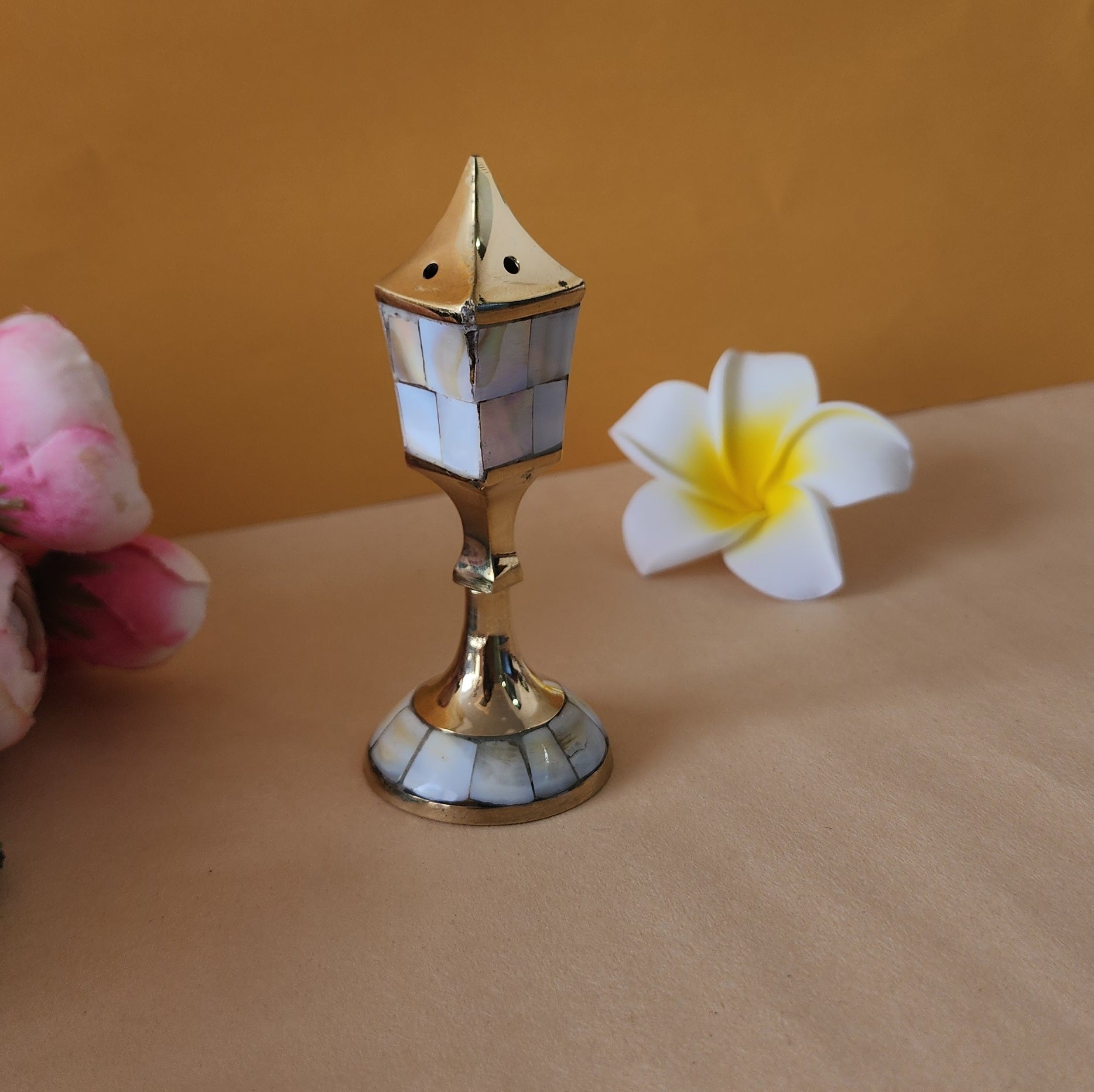 incense holder with flowers behind it