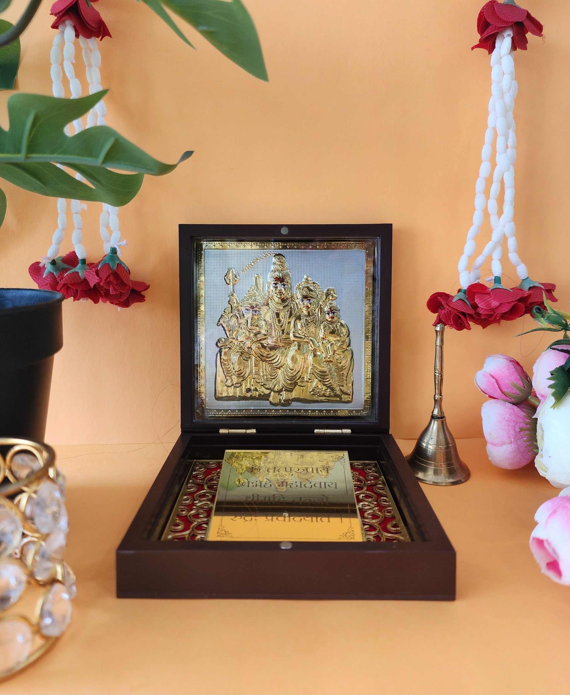 A beautifully crafted wooden box opened to reveal a gold-plated idol or frame depicting the Shiva Parivar (Lord Shiva, Goddess Parvati, Lord Ganesha, and Lord Kartikeya) inside, presented as a portable or pocket temple.