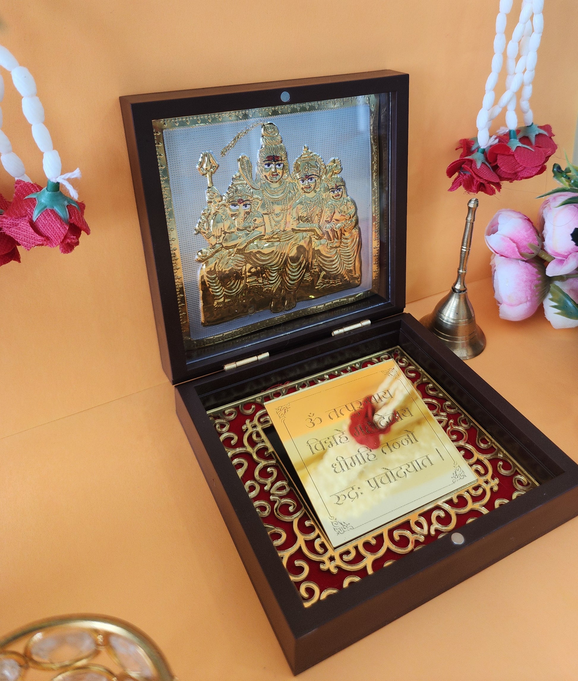 An open, ornate wooden box serving as a "pocket temple," featuring a golden relief of the Shiva Parivar (Lord Shiva, Goddess Parvati, Lord Ganesha, and Lord Kartikeya) in the lid and a golden plate with a mantra and floral design in the main compartment.
