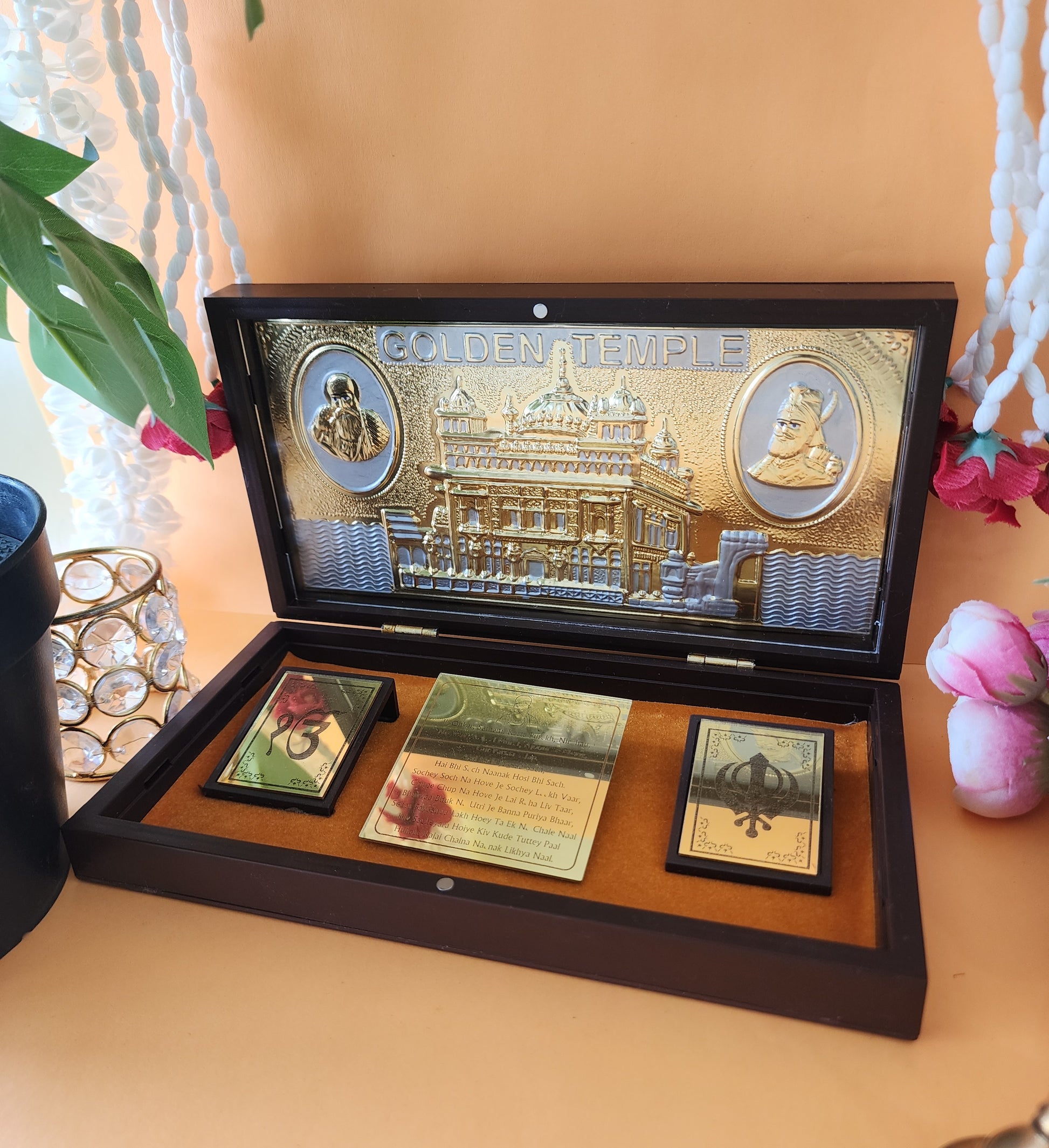 Golden Temple Pocket Temple  with white mala around it and flowers around it