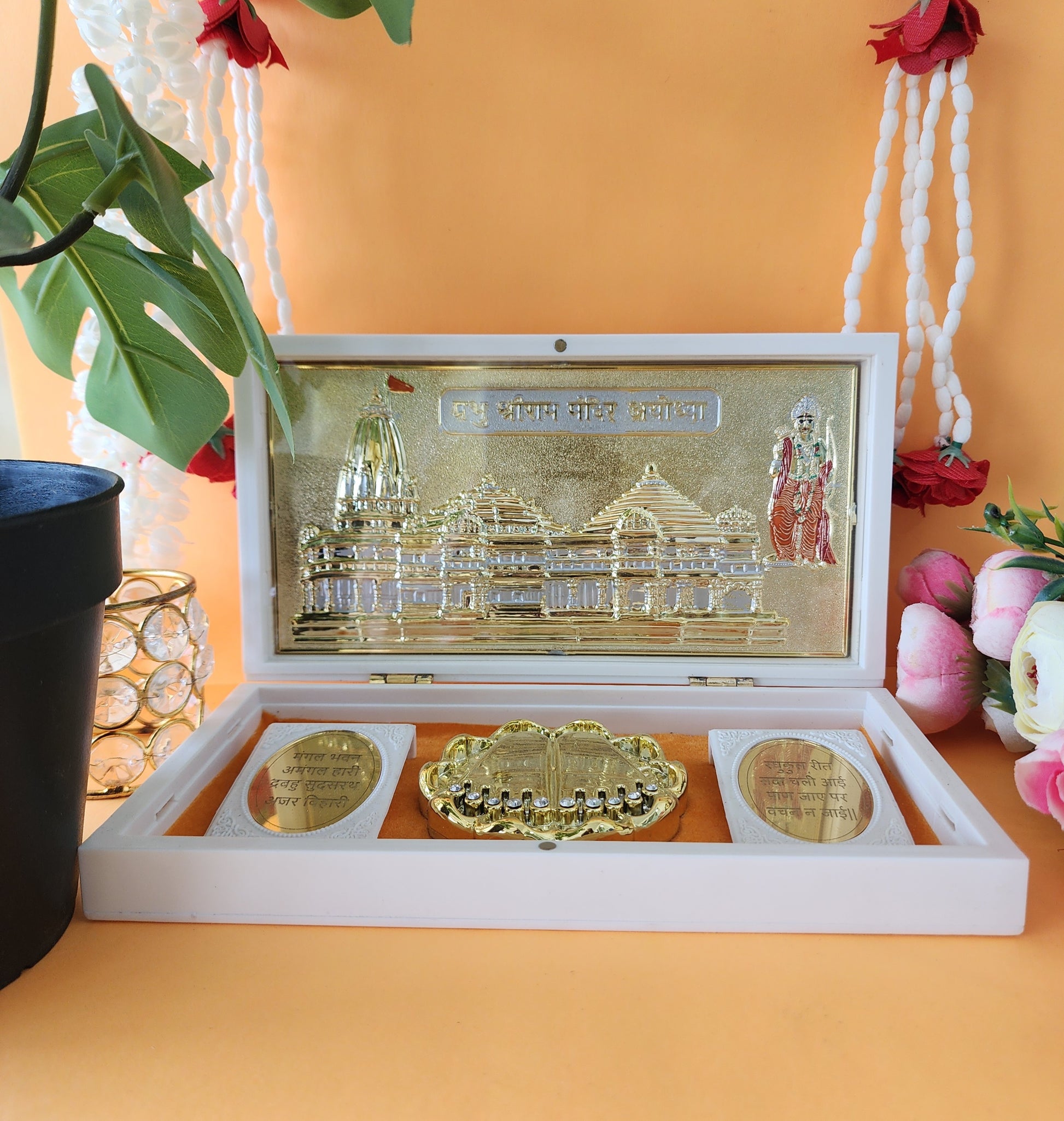 Gold-plated model of the Ram Mandir within a white presentation box, showcasing intricate details and spiritual elements.