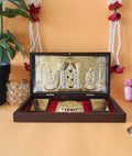 A close-up of a gold-plated Lord Balaji Laxmi Padmavati Pocket Temple within an open brown wooden box, featuring intricately detailed idols of Lord Balaji in the center, flanked by Goddess Laxmi and Goddess Padmavati, designed for portable devotion or as a gift