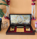 A meticulously crafted Lord Shiva pocket temple in a wooden box, featuring a central gold-plated idol of Lord Shiva and smaller golden plaques with 'Om Namah Shivaya'  inscribed. The temple is surrounded by traditional Indian decorative elements, including red and white floral garlands and a golden votive candle holder, all set against a warm, plain background.