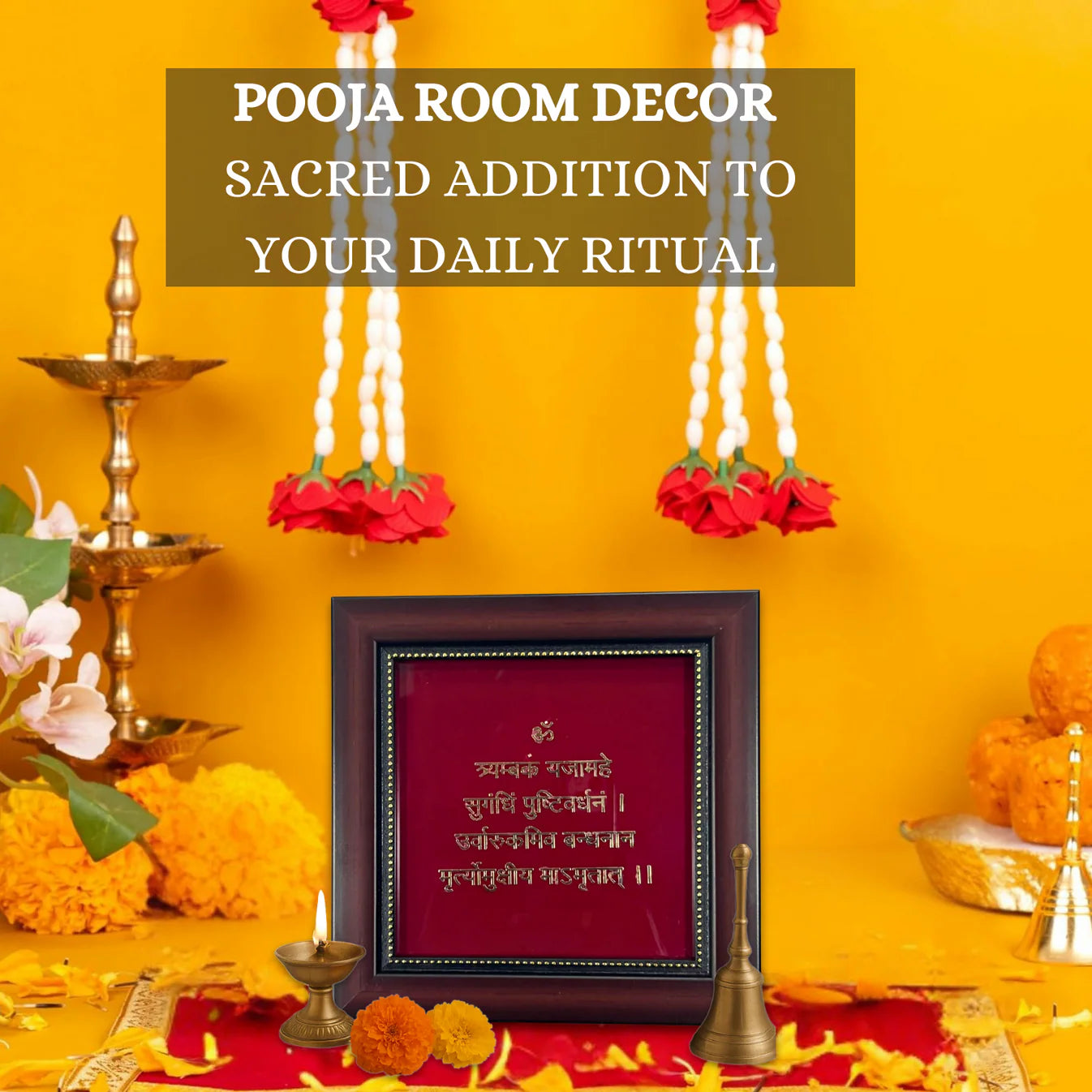 A framed image of the Mahamrityunjaya Mantra on a red background is surrounded by traditional Hindu puja items, including a lit oil lamp (diya), flowers, and a bell. The image has a text overlay that reads "POOJA ROOM DECOR SACRED ADDITION TO YOUR DAILY RITUAL."