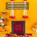 A decorative Hindu puja room setup featuring a prominent wooden photo frame with gold trim displaying a sacred mantra in Sanskrit, surrounded by traditional elements like brass oil lamps, a bell, and vibrant marigold flowers, all set against a warm yellow background. The text