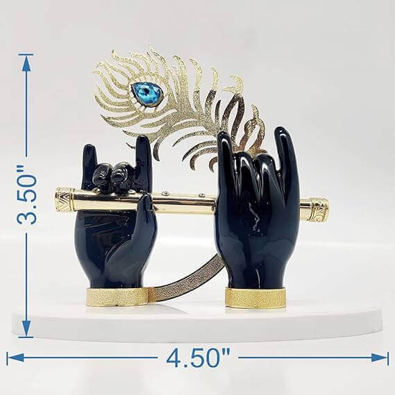 A decorative figurine depicting Lord Krishna's hands in a dark finish, holding a golden flute and a golden peacock feather, displayed on a white base with indicated dimensions of 3.50" height and 4.50" width.
