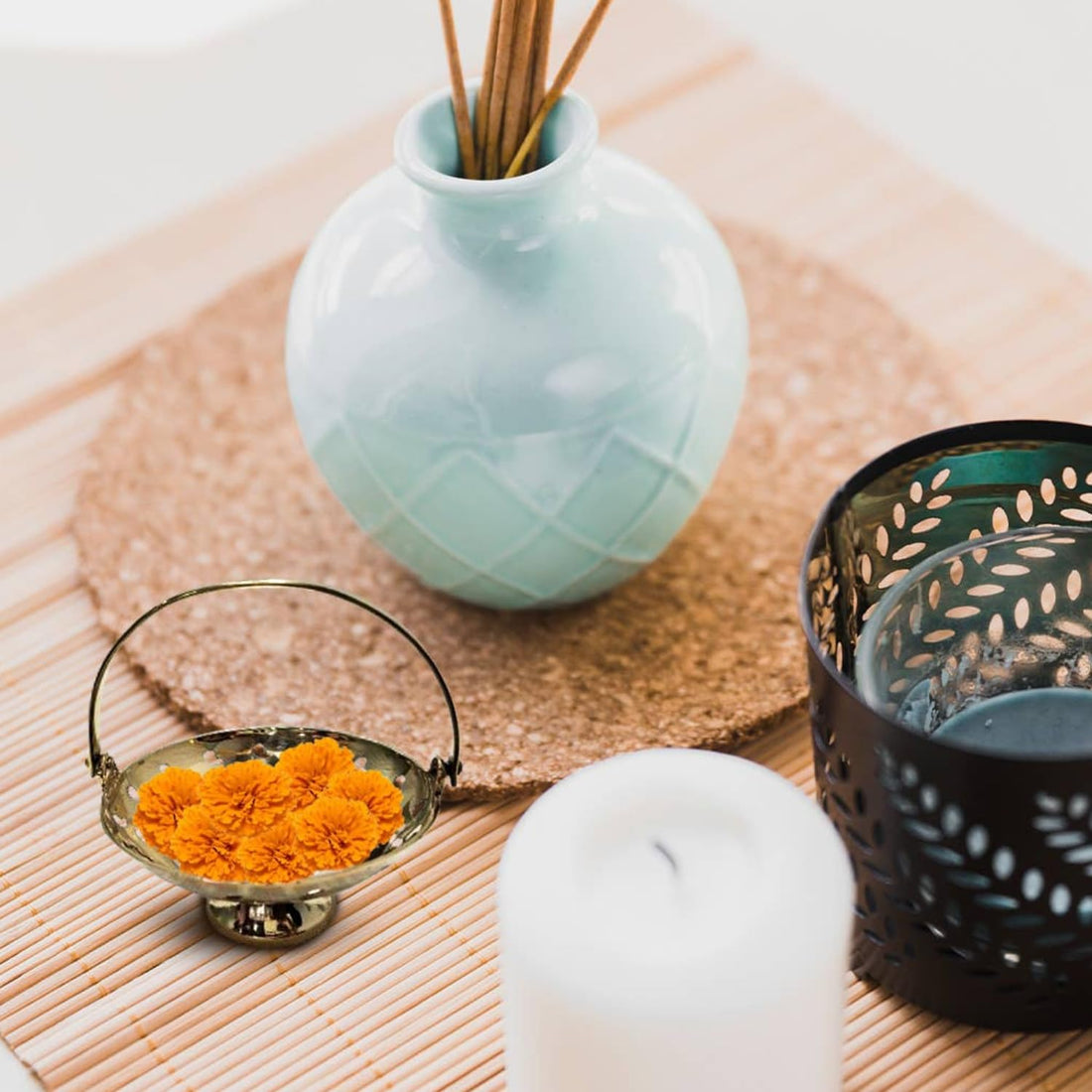 A handcrafted brass flower basket with mother of pearl inlays, placed on a bamboo mat.
