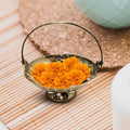 Brass Flower Basket with orange flowers in it on wooden floor
