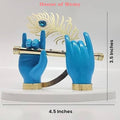 A decorative idol featuring two blue hands, likely representing Lord Krishna's, holding a golden flute. A golden peacock feather with a blue gem is positioned behind the hands, all resting on a white oval base. The image also displays text indicating the dimensions