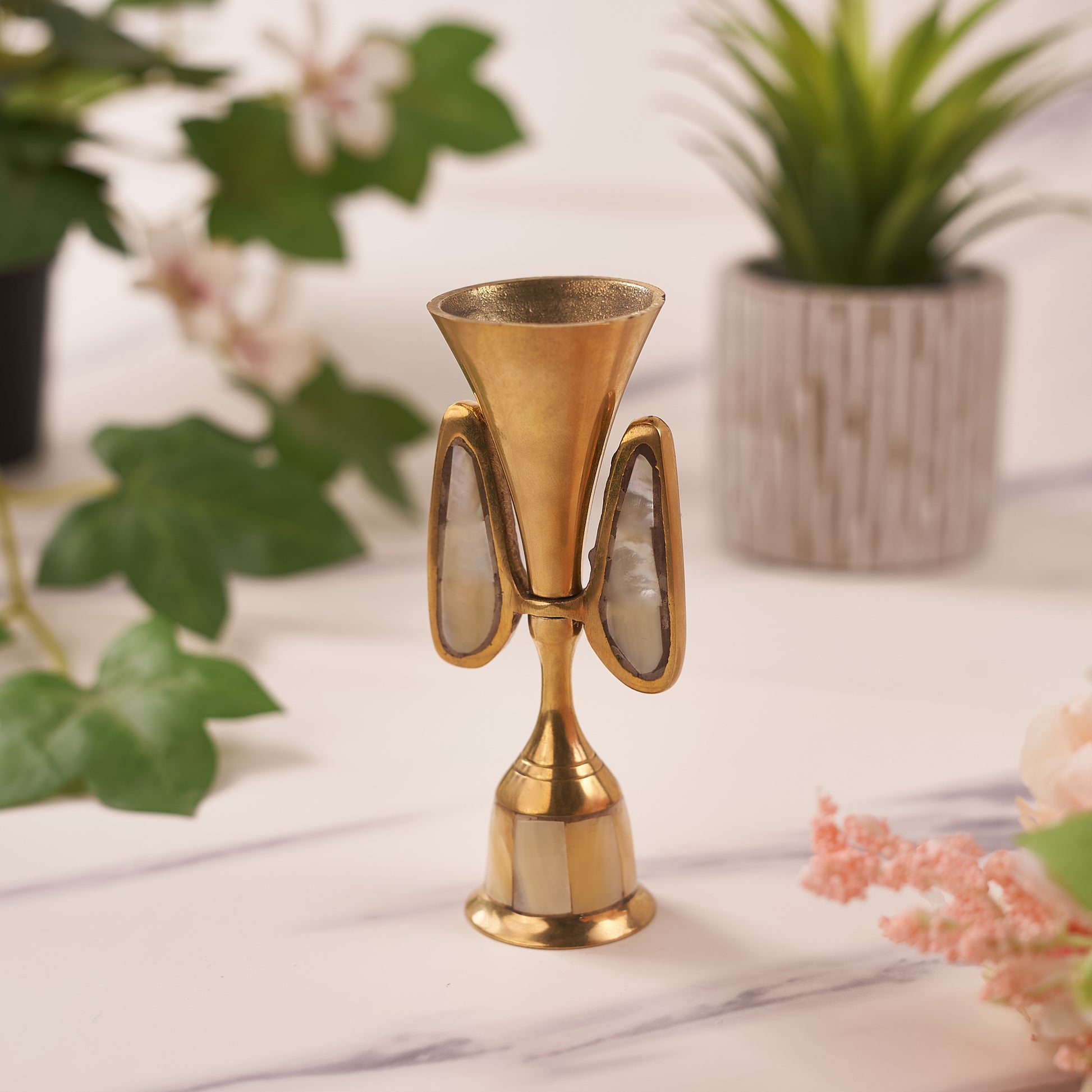 single Brass Candle Holder with leaves behind it