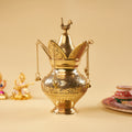 a brass klash with sarasvati idol behind