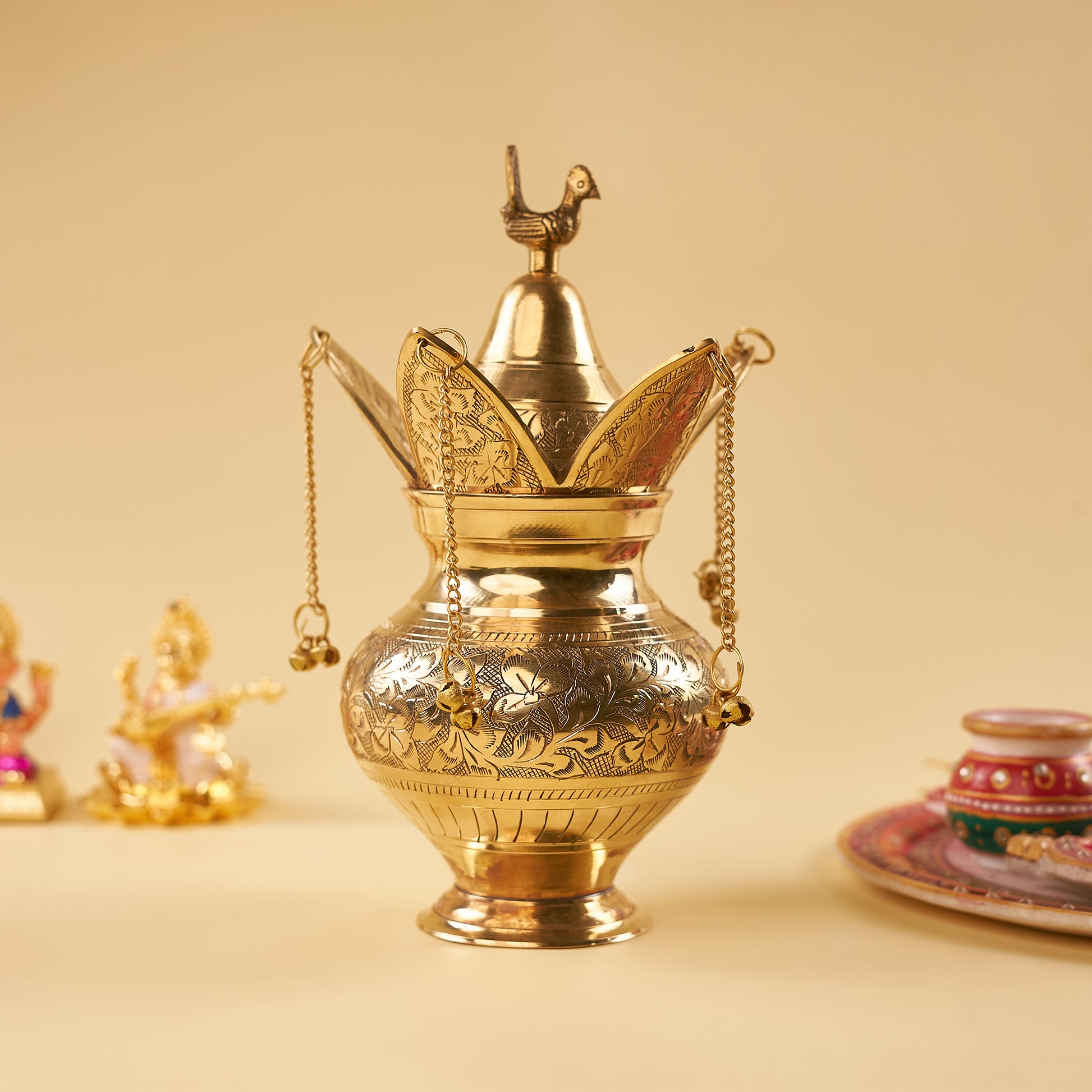 a brass klash with sarasvati idol behind
