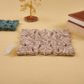 A wooden carved trivet with an antique white finish with green trivet set behind it