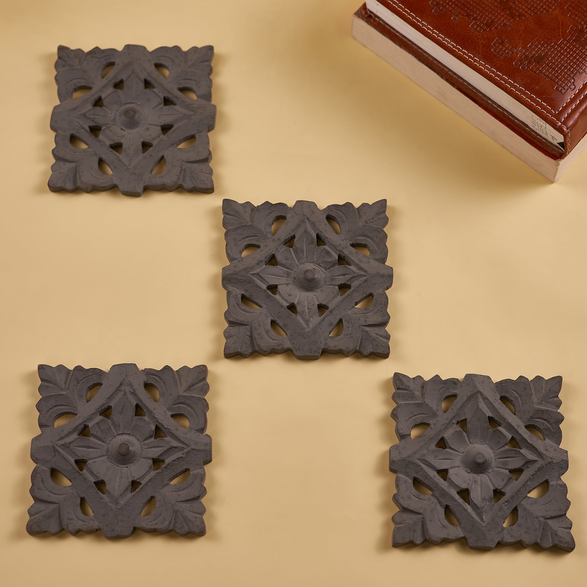 A set of four dark grey wooden coasters with red dairy on the side