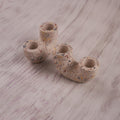 A pair of U-shaped, terrazzo-style Ceramic Curve Candle Holder Set of 2 is displayed on a light wooden background. The speckled design features small, colorful flecks, and each holder has two openings for taper candles.