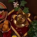 Brass lota on the red chariot with pooja thali and bell around it upper angel photo