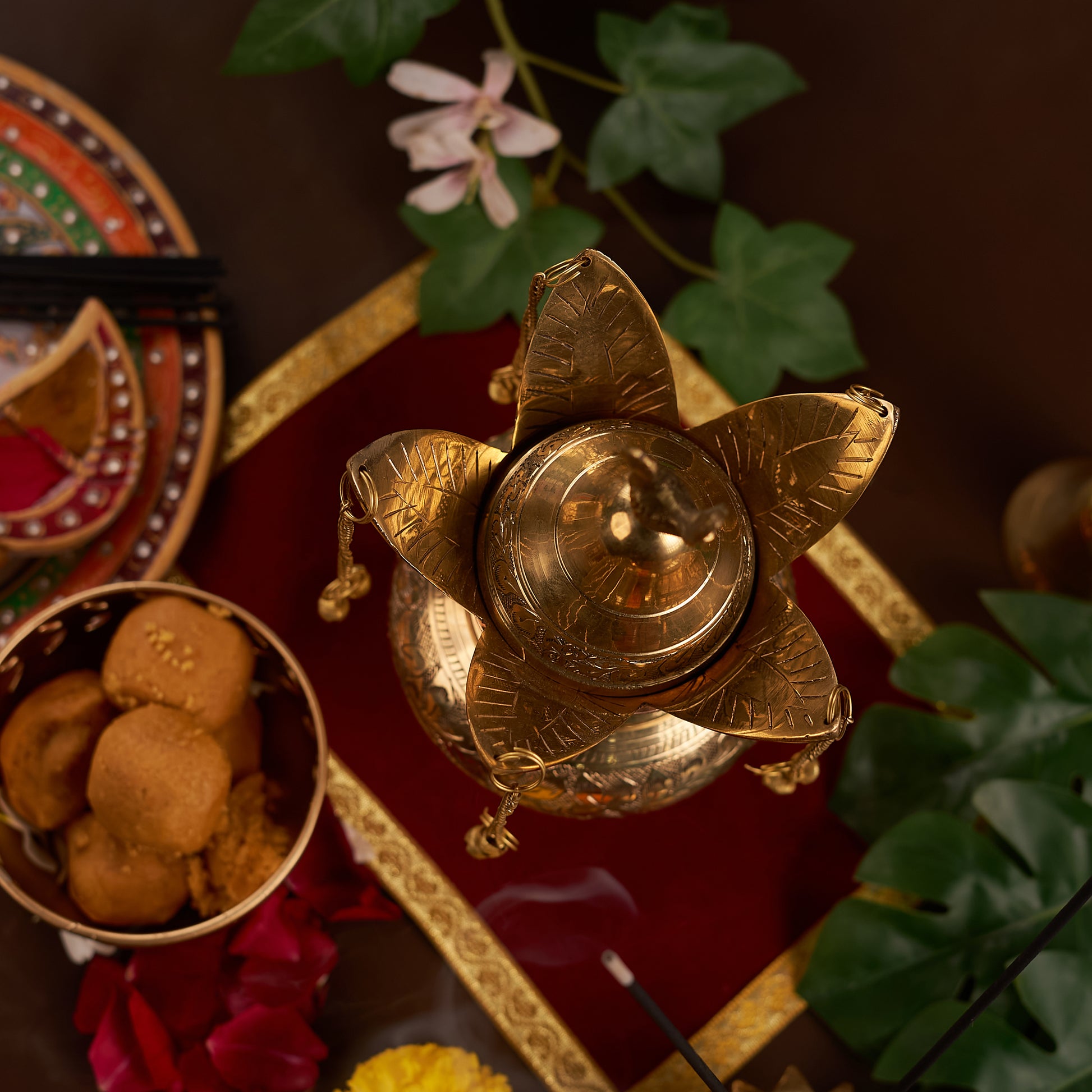 Brass lota on the red chariot with pooja thali and bell around it upper angel photo