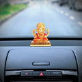 Dagdushet Ganesha car Idol Gold on the black car dashboard