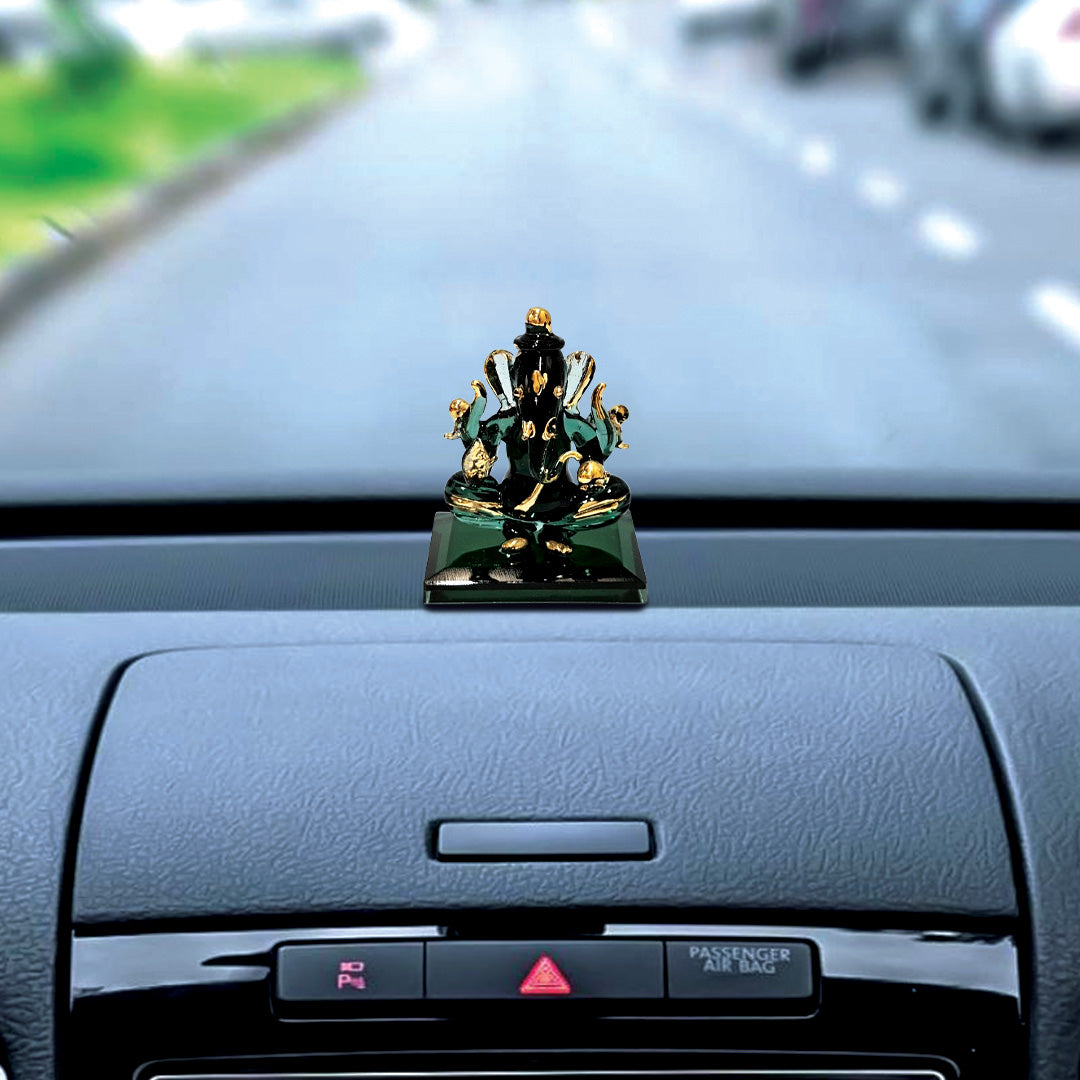 A crystal finish statue of Ganesh, the Hindu deity, with a green and gold color scheme, sitting on a square base.