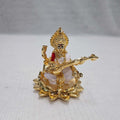 A gold-plated statue of Goddess Saraswati seated on a lotus and playing the veena.