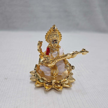 A gold-plated statue of Goddess Saraswati seated on a lotus and playing the veena.