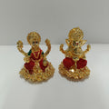 The image displays a set of gold-plated idols featuring the Hindu deities Goddess Lakshmi and Lord Ganesha.