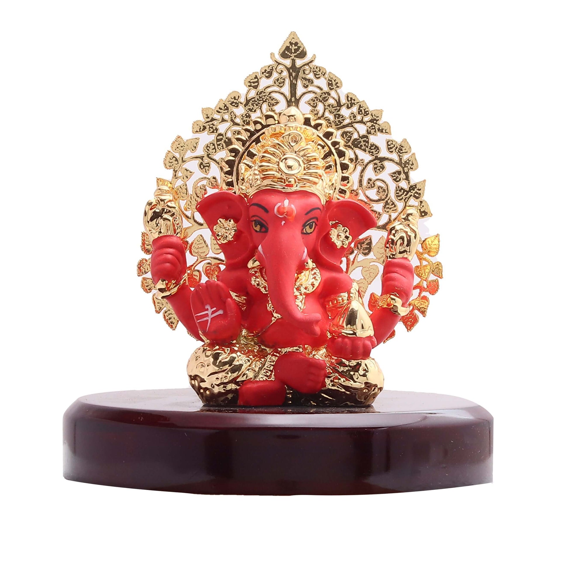 A red and gold Ganesha idol with a golden, leaf-patterned halo (Kalpavriksha tree design) seated on a dark wooden base.