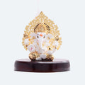 White and gold Ganesha idol with a golden Kalpavriksha tree design on a dark brown base.