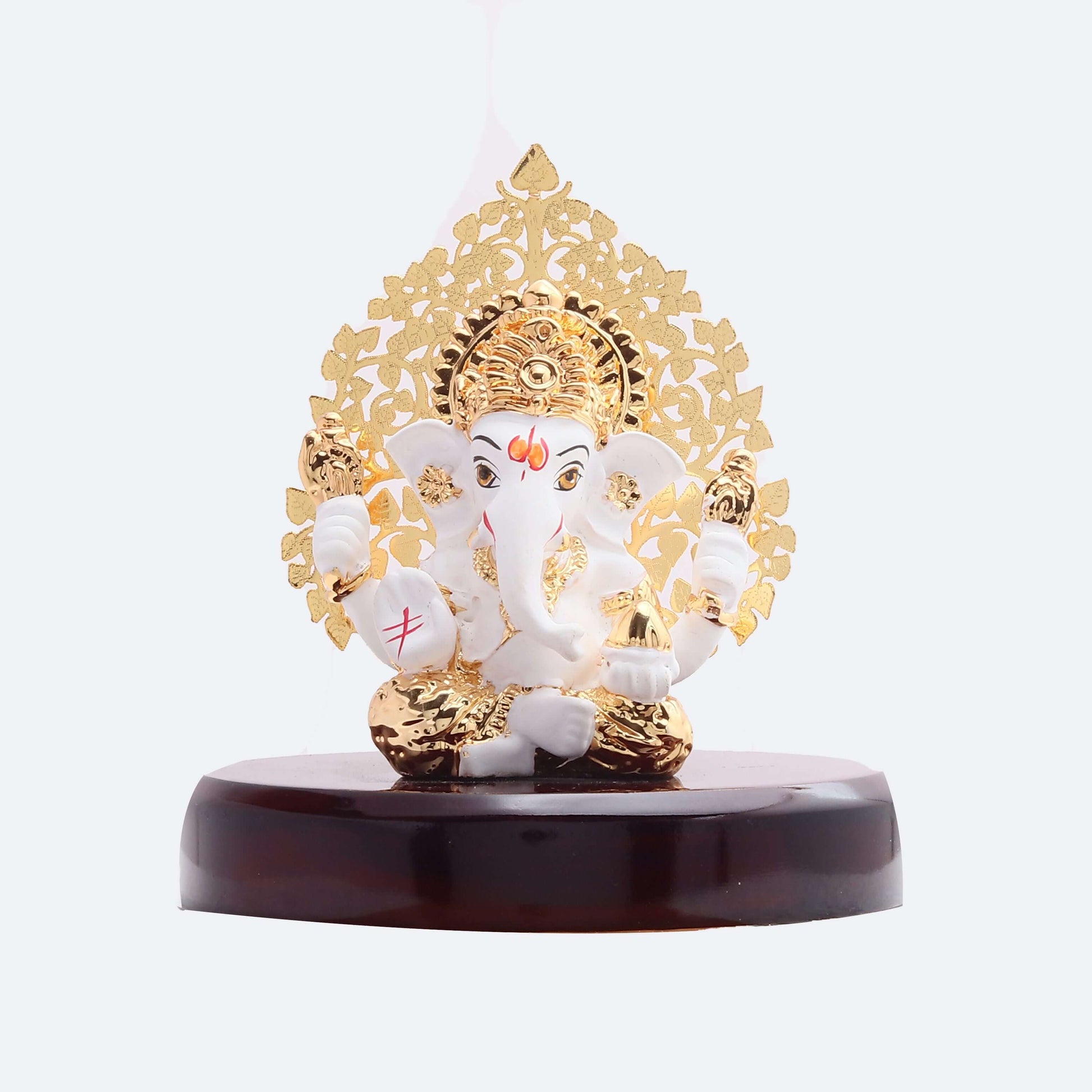 White and gold Ganesha idol with a golden Kalpavriksha tree design on a dark brown base.
