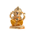 Golden Ganesha idol sitting with a red tilak on his forehead.