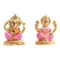 Golden idols of Lord Ganesha and Goddess Lakshmi with pink clothing accents, commonly worshipped together during Hindu festivals like Diwali.