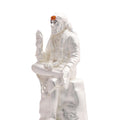 A white statue of Shirdi Sai Baba in a seated, meditative pose with his right hand raised in a blessing gesture, wearing a headscarf and a garland.