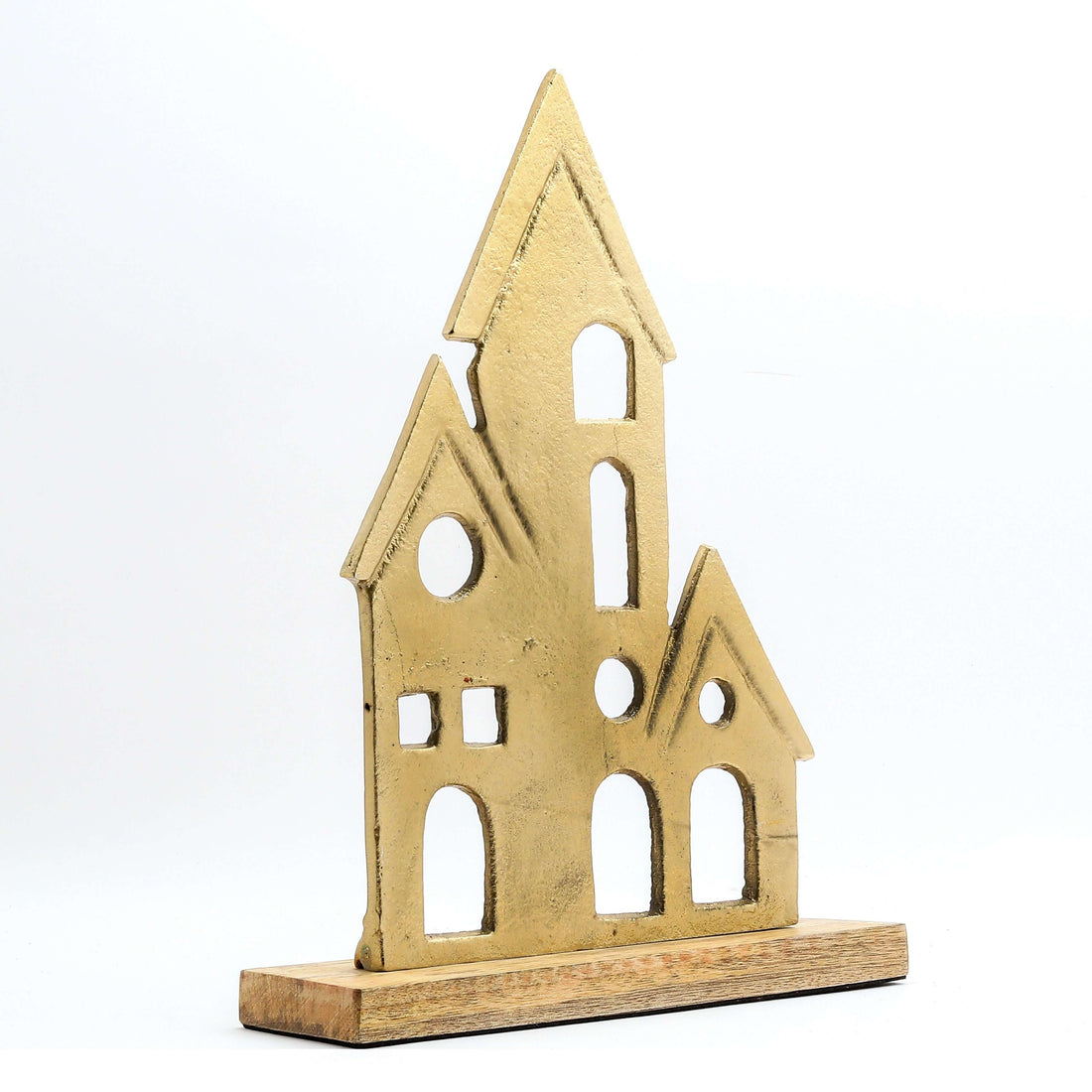 A gold-colored elegant home decor figurine of a house is featured on a light-colored wooden base. The figurine has a textured, matte finish and is composed of three interconnected house-like shapes of varying sizes, each with pointed roofs and several stylized window and door cutouts. The item is displayed against a white background.