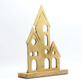 A gold-colored elegant home decor figurine on a wooden base is featured. The figurine has a textured, matte finish and is composed of three interconnected house-like shapes of varying sizes, each with pointed roofs and several stylized window and door cutouts. The wooden base is a light-colored wood. The item is displayed against a white background.