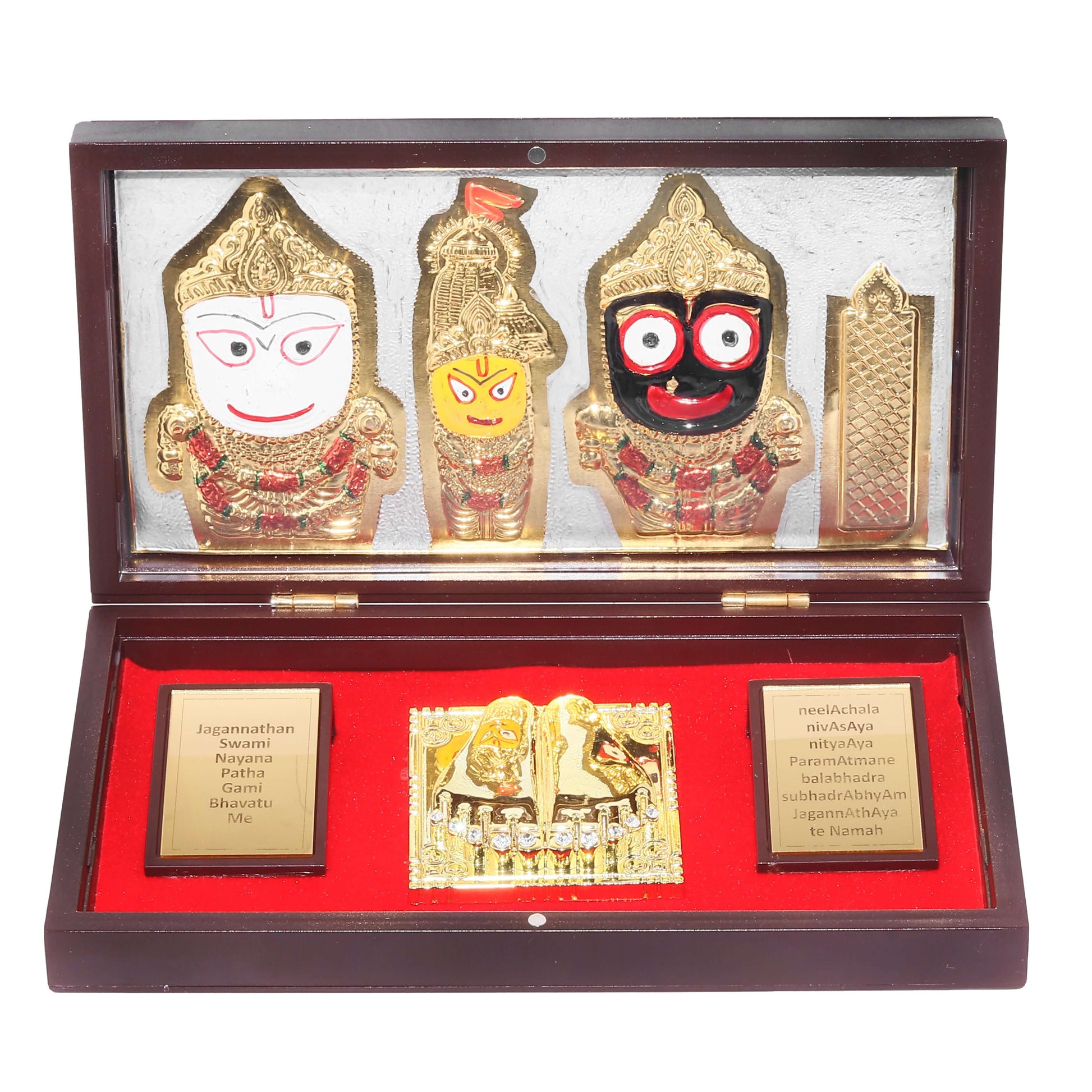 A decorative wooden box with a glass top displays gold-plated idols of Lord Jagannath, Lord Balabhadra, and Goddess Subhadra, alongside a golden Charan Paduka and inscribed plaques with Sanskrit text on a red velvet lining
