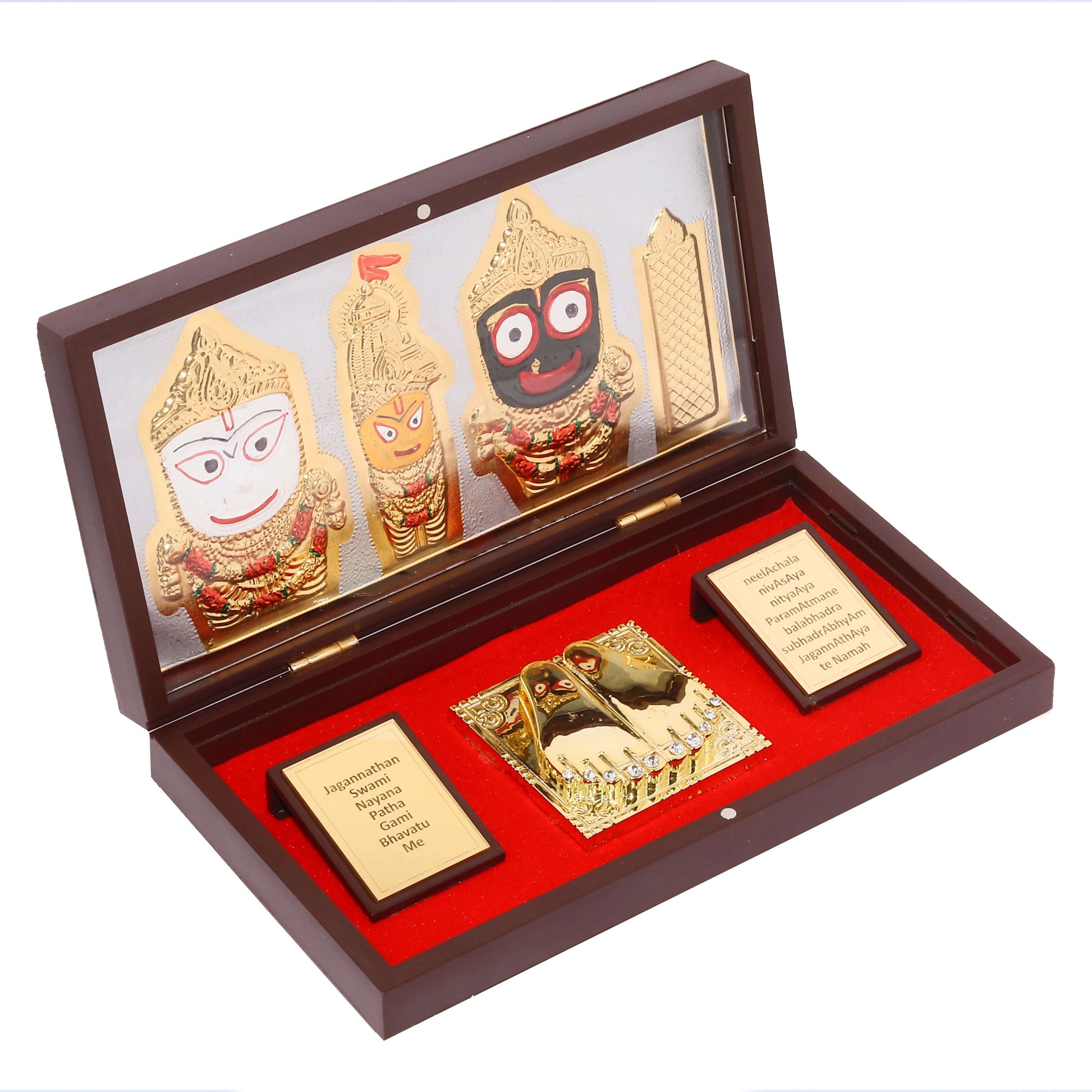 A polished wooden box frame, open to reveal gold-plated figurines of Lord Jagannath, Lord Balabhadra, and Devi Subhadra on the left, and a pair of gold-plated Charan Padukas (sacred footprints) on a red base on the right. Two small, inscribed golden plaques are also visible, one on each side of the Padukas