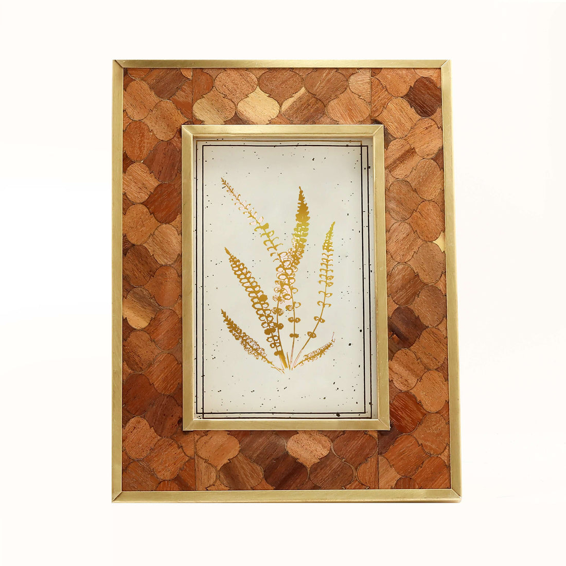 A teakwood frame with a geometric pattern, displaying a floral image, placed on a shelf with books and a plant in the background.