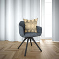 A beige and black tribal motif pillow cover on a gray chair