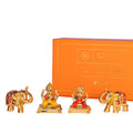 Lakshmi and Ganesha idols flanked by two elephants in front of an orange gift box.