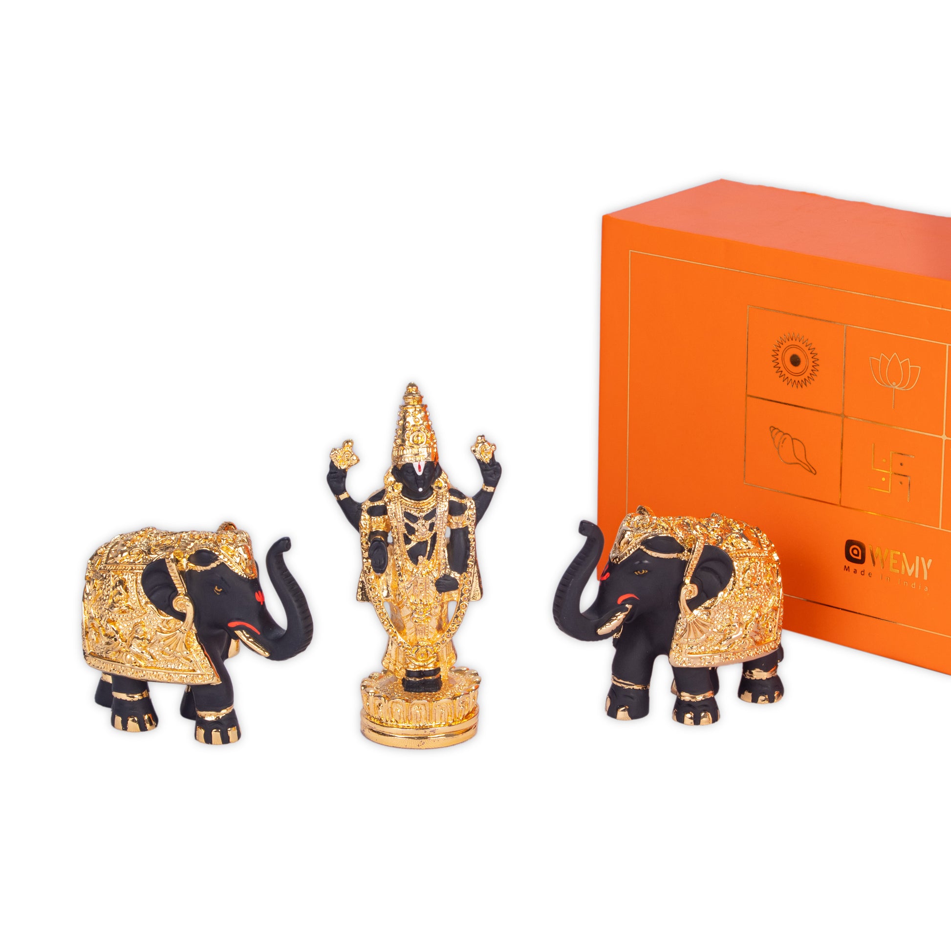 A gold-plated Balaji idol in black, flanked by two black and gold elephant statues, with an orange gift box featuring the 'WEMY' logo in the background.
