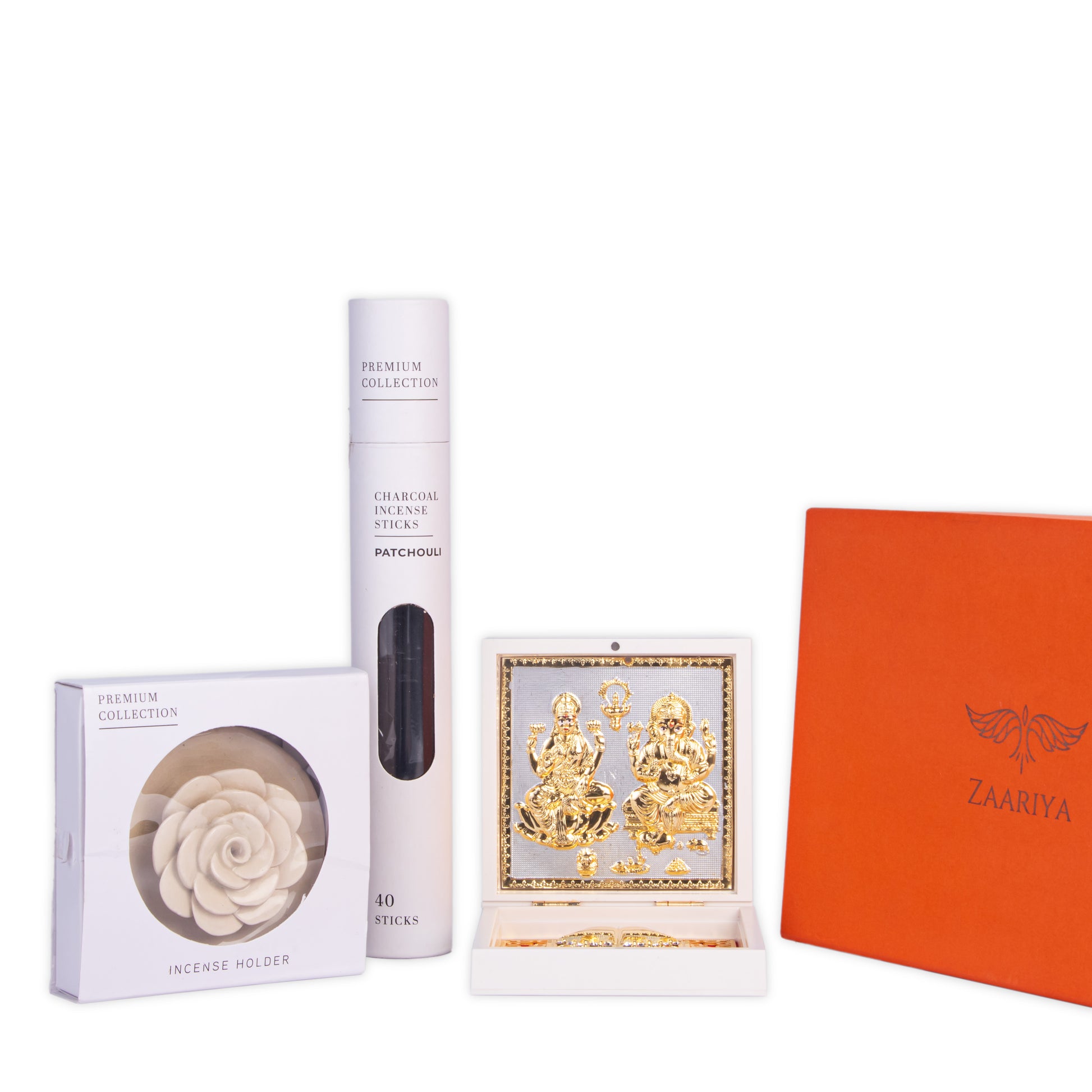 A collection of spiritual items including golden Lakshmi Ganesha deities in a white frame, a pack of Zaariya Patchouli charcoal incense sticks, and a white rose-shaped incense holder.